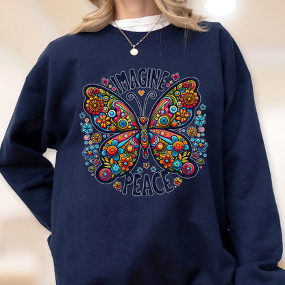 May include: Navy blue sweatshirt featuring a colorful butterfly design with the words "IMAGINE" and "PEACE". The butterfly is adorned with flowers in shades of orange, yellow, pink, and blue. A necklace is visible at the neckline.