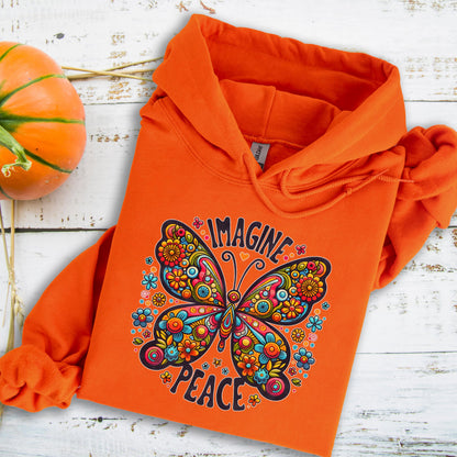 May include: Orange hoodie featuring a colorful butterfly design with the words "IMAGINE PEACE". The butterfly is adorned with flowers in shades of blue, orange, and yellow. The hoodie has a drawstring hood and a kangaroo pocket.