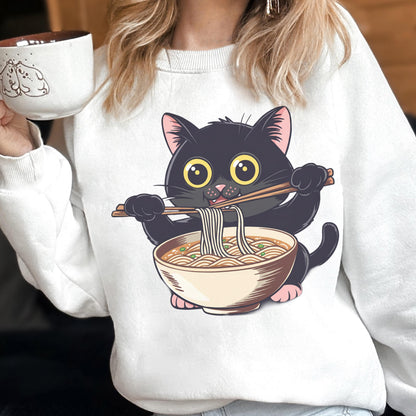 May include: White sweatshirt featuring a cartoon black cat eating ramen with chopsticks. The cat has large yellow eyes and pink ears and paws. The ramen bowl is beige with noodles and green garnish. A brown and white mug is held in the upper left.