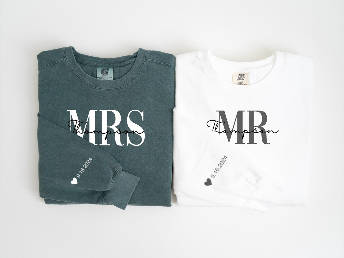 May include: Two long-sleeved shirts, one teal and one white, are displayed. The teal shirt says "MRS Thompson" in white script, with "9.16.2024" and a heart on the sleeve. The white shirt says "MR Thompson" in black script, with "9.16.2024" and a heart on the sleeve.