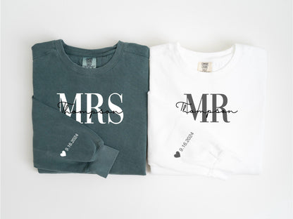 May include: Two long-sleeved shirts, one teal and one white, are displayed. The teal shirt says "MRS Thompson" in white script, with "9.16.2024" and a heart on the sleeve. The white shirt says "MR Thompson" in black script, with "9.16.2024" and a heart on the sleeve.