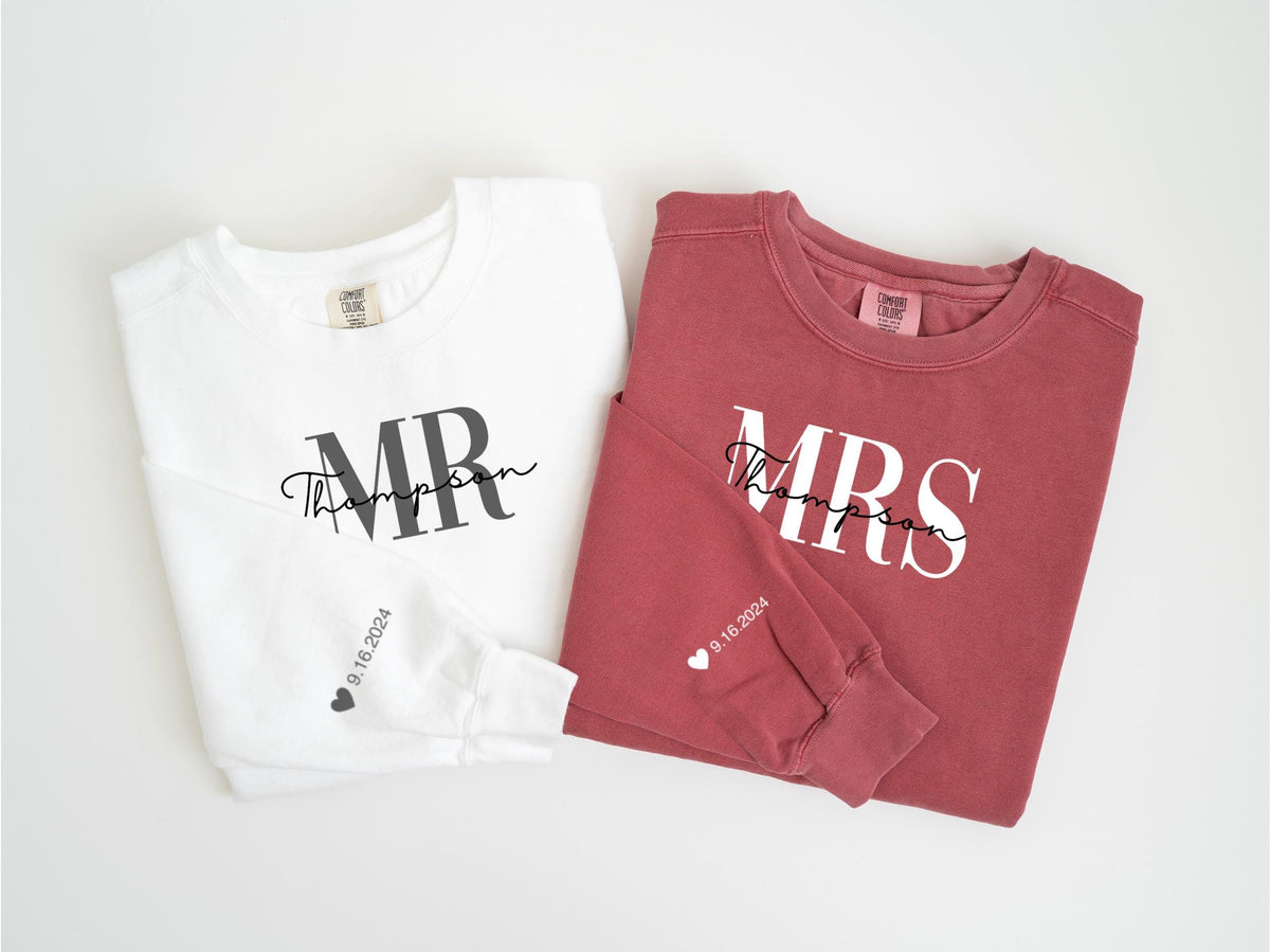 May include: Two long-sleeved shirts, one white and one burgundy, are displayed. The white shirt has "MR Thompson" printed on the front, and the burgundy shirt has "MRS Thompson". Both sleeves have the date "9.16.2024" and a heart.