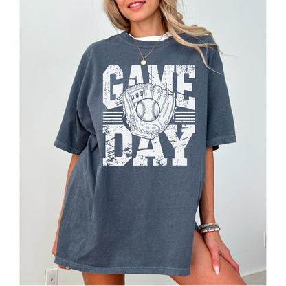 May include: Dark grey t-shirt with the words "GAME DAY" in white block letters. A baseball and glove graphic is centered on the shirt. The shirt has short sleeves and a relaxed fit.