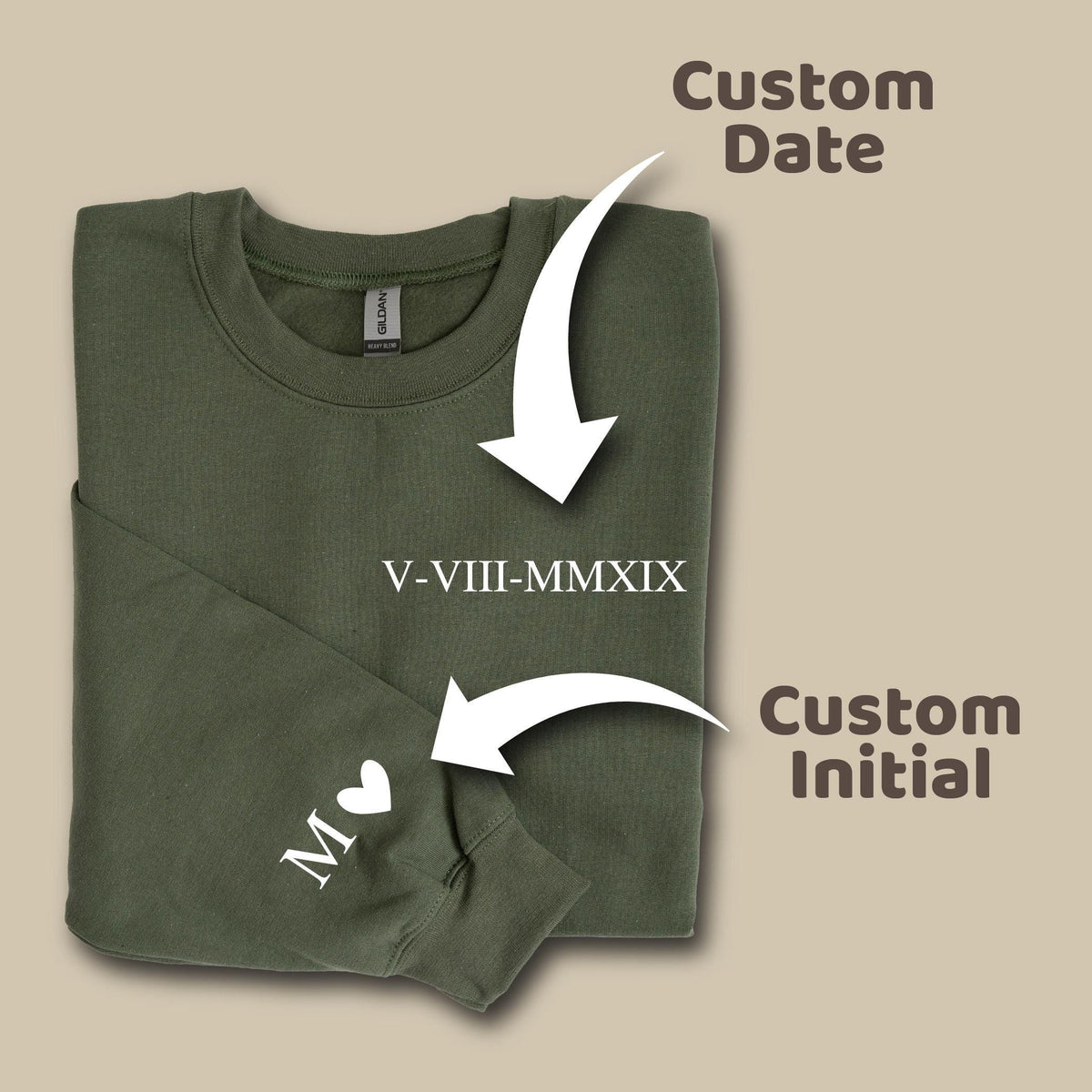 May include: An olive green crewneck sweatshirt featuring the Roman numeral date V-VIII-MMXIX printed on the chest and a white letter M followed by a heart symbol printed on the sleeve, with text labels indicating custom date and custom initial.
