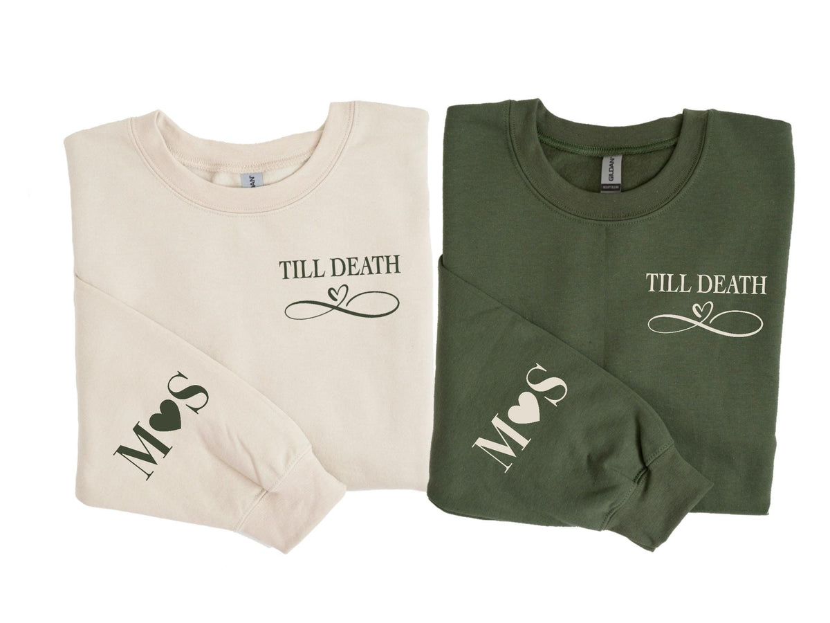 May include: Two long-sleeved sweatshirts, one cream and one olive green, are displayed. Each has the phrase "Till Death" with a heart-shaped infinity symbol. The left sleeve of each shirt has initials and a heart.