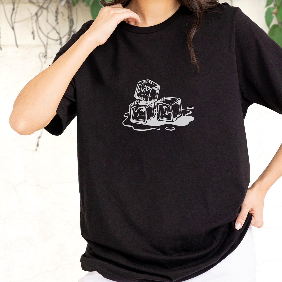 May include: Black t-shirt featuring a graphic of three melting ice cubes in a minimalist style. The ice cubes are white with gray shading, and the melting water is also gray. The shirt is a classic crew neck.