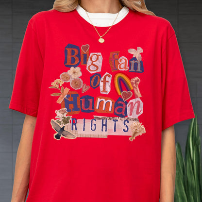 May include: Red t-shirt with the text "Big fan of Human Rights" in a collage style. The design includes a rainbow, hearts, flowers, and a raised fist. The shirt has a white crew neck collar.