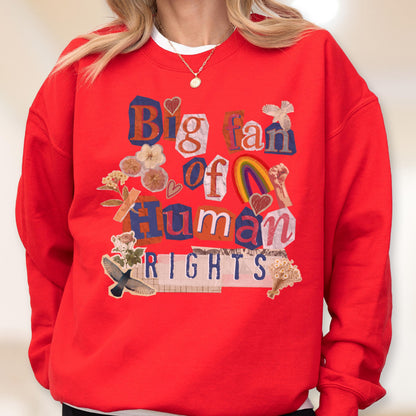 May include: A red sweatshirt with the words "Big fan of Human Rights" in a collage style. The design includes a rainbow, hearts, and floral elements. The sweatshirt has a crew neck and long sleeves.