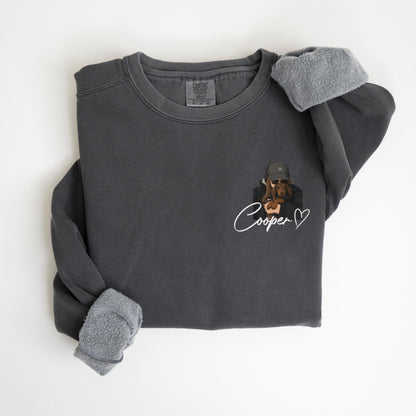 May include: Dark gray sweatshirt with a dog graphic wearing a hat and sunglasses. The name "Cooper" is written in cursive below the graphic, with a heart symbol. The sleeves have a soft, gray lining.