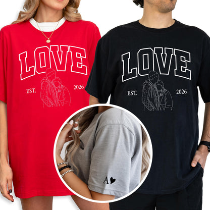 May include: Red and black t-shirts with the word "LOVE" in white block letters. Each shirt features a line drawing of a couple and the text "EST. 2026". A gray t-shirt has the letter "A" and a heart on the sleeve.