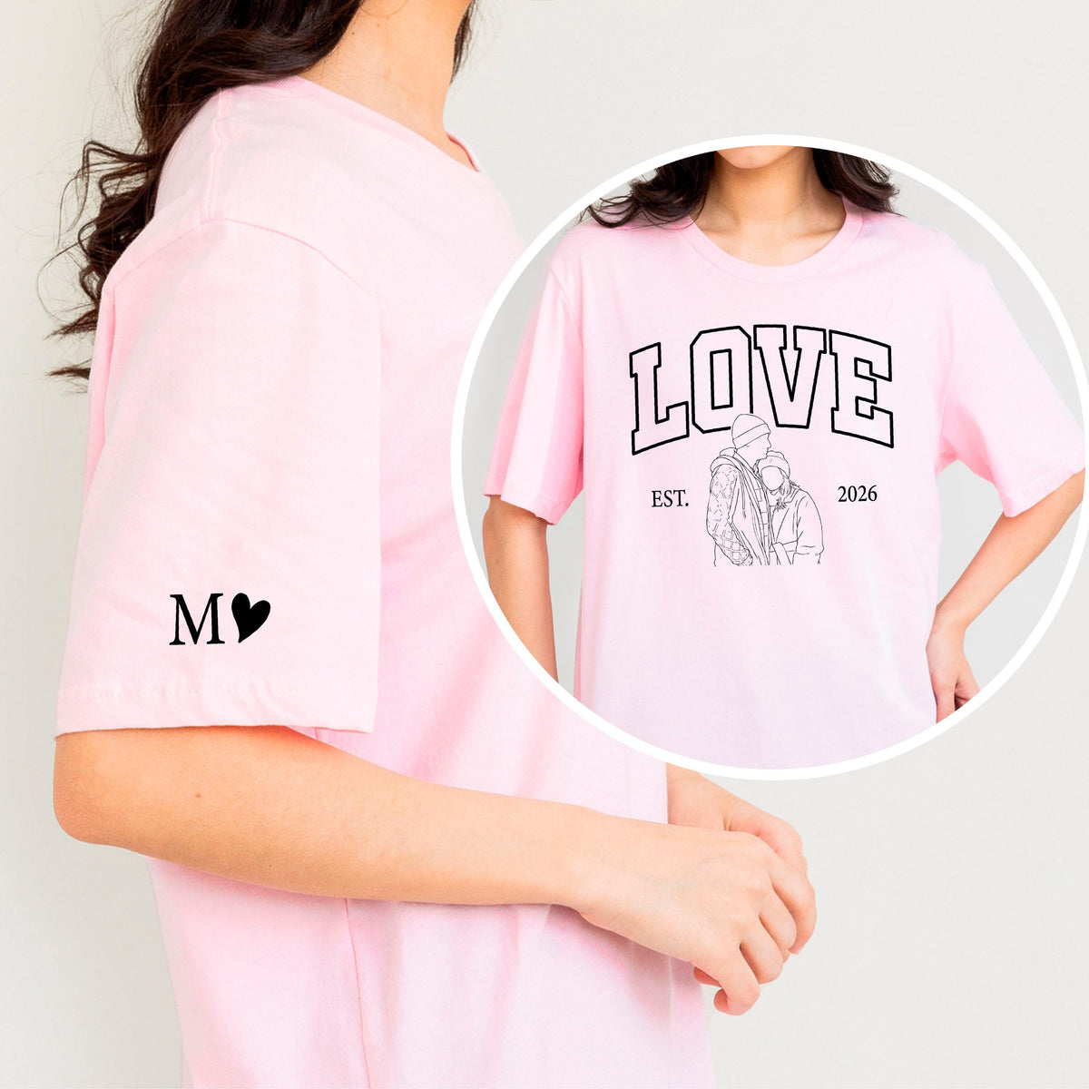 May include: A light pink t-shirt with the word "LOVE" in a collegiate font, a line drawing of a couple, and the text "EST. 2026". The left sleeve has the letters "M" and a heart symbol. The shirt is a casual style.
