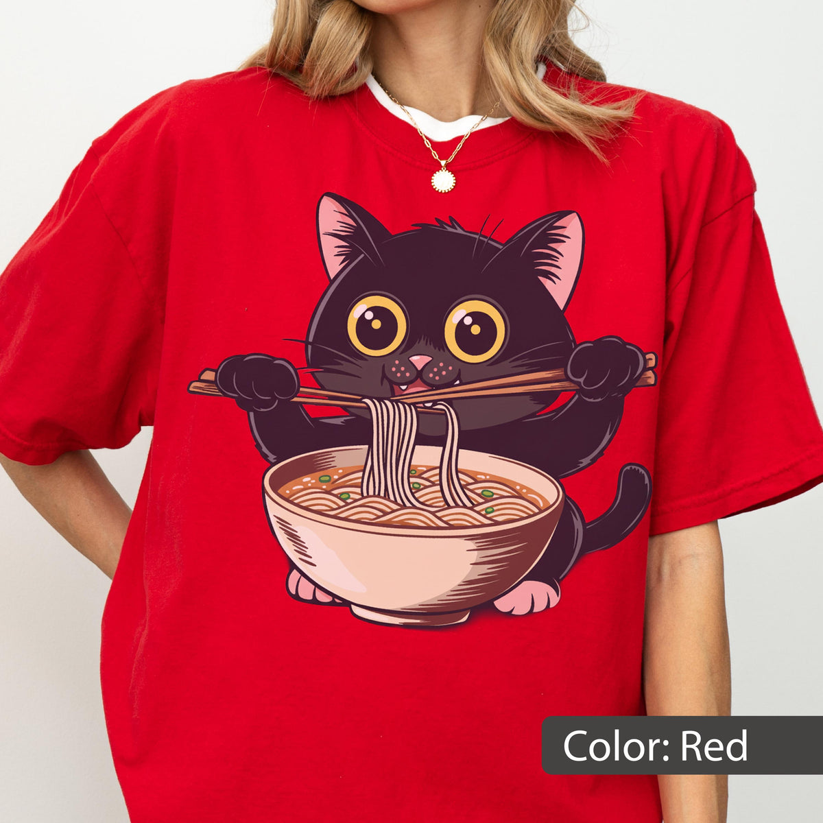 May include: Red t-shirt featuring a cartoon black cat eating ramen noodles with chopsticks. The cat has large yellow eyes and is holding a bowl of noodles. The text "Color: Red" is at the bottom of the image.