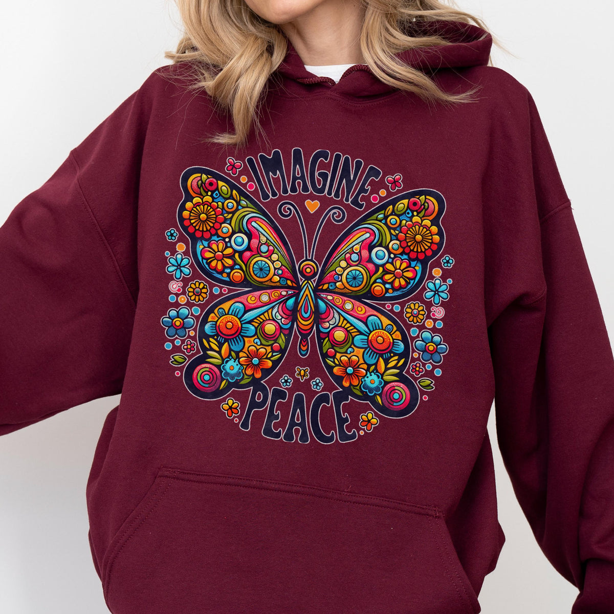 May include: Burgundy hoodie featuring a colorful butterfly design with the words "IMAGINE" and "PEACE". The butterfly is adorned with flowers in shades of orange, yellow, blue, and pink.