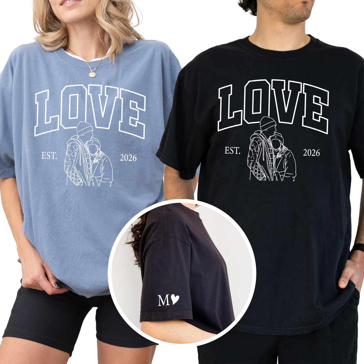 May include: Two oversized t-shirts, one blue and one black, each with the word "LOVE" in a collegiate font. Below the word is a line drawing of two people embracing, with "EST. 2026" underneath. The black shirt has "M♥" on the sleeve.