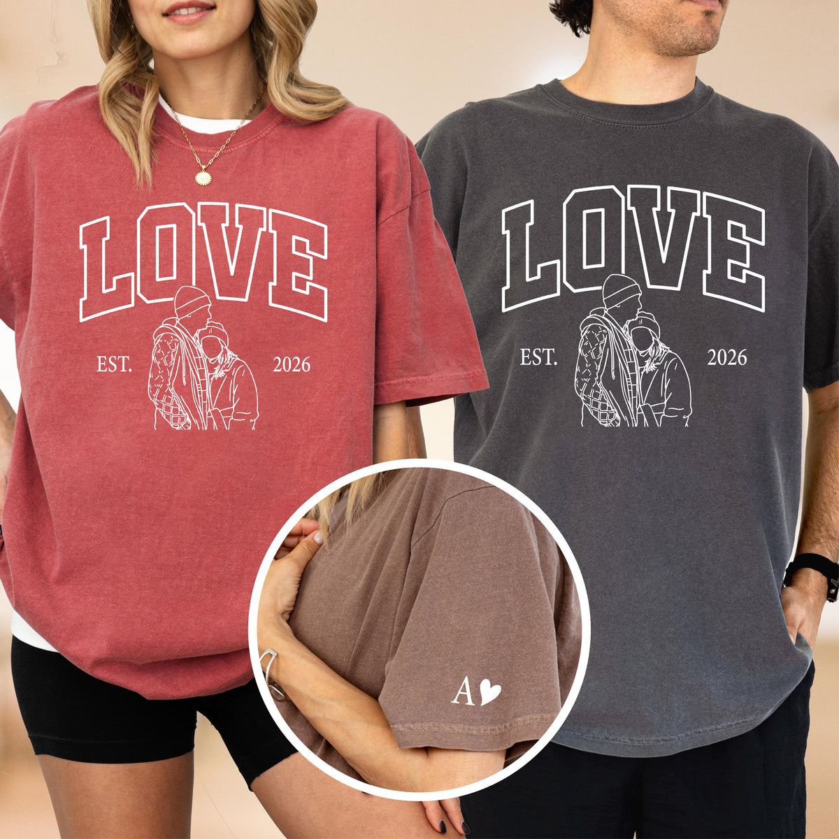 May include: Two short-sleeved t-shirts, one red and one charcoal gray, with the word "LOVE" in white block letters. Below the word "LOVE" is a line drawing of two people embracing, with the text "EST. 2026". The red shirt has a white heart and the letter "A" on the sleeve.