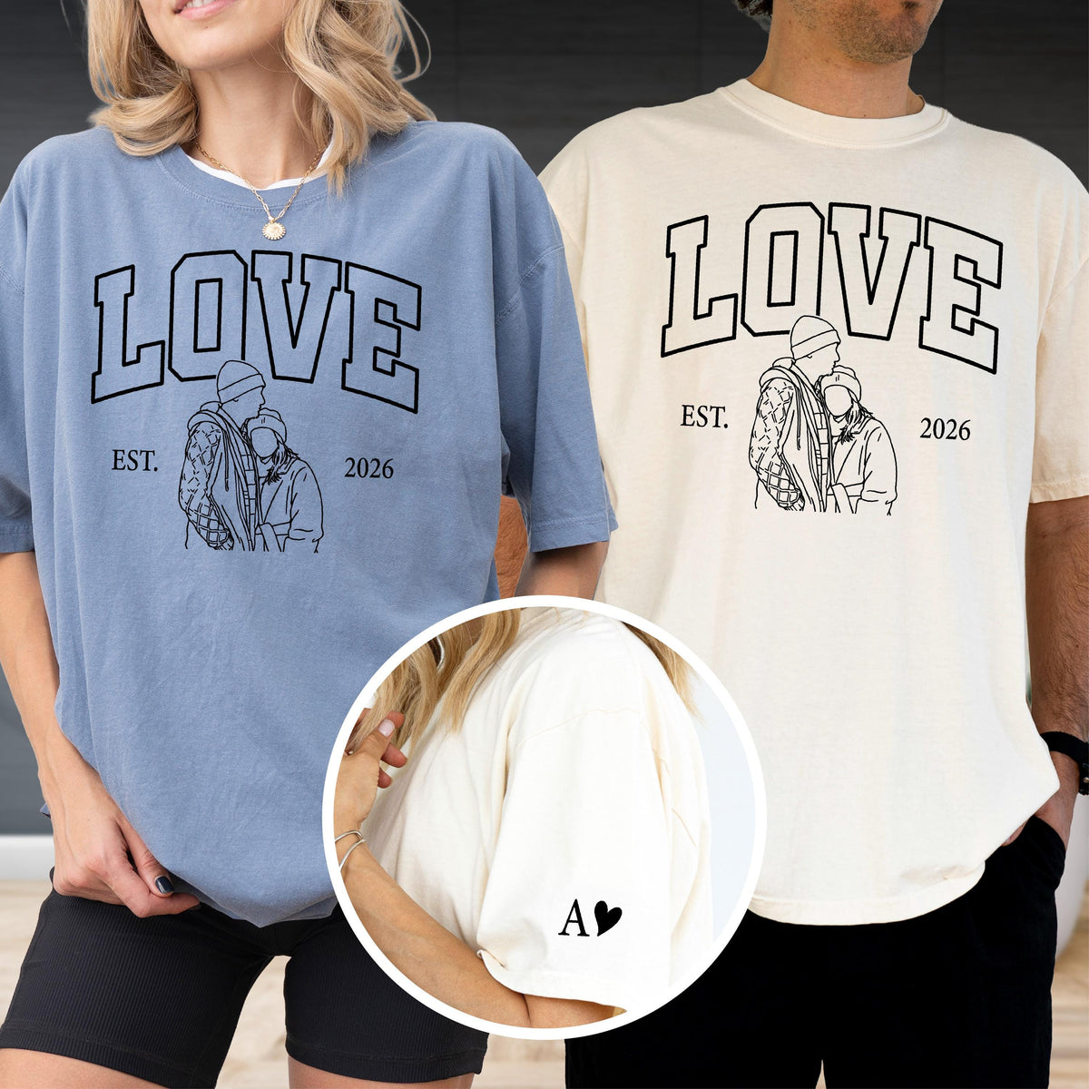 May include: Two oversized t-shirts, one light blue and one cream, featuring the word "LOVE" in a bold, black, collegiate-style font. Below the word is a line drawing of a couple and the text "EST. 2026". The left sleeve of the cream shirt has the letter "A" and a heart.