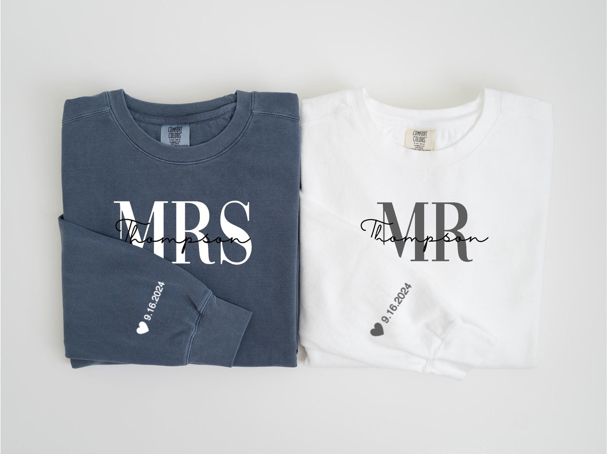 May include: Two long-sleeved sweatshirts, one navy blue and one white. The navy blue sweatshirt says "MRS Thompson" in white script, and the white sweatshirt says "MR Thompson" in black script. Both sleeves have the date "9.16.2024".