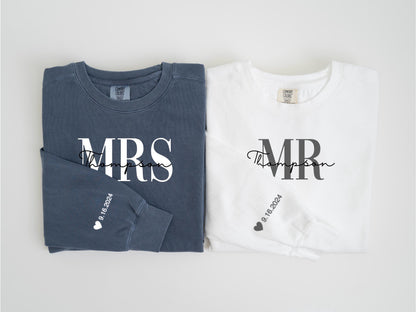 May include: Two long-sleeved sweatshirts, one navy blue and one white. The navy blue sweatshirt says "MRS Thompson" in white script, and the white sweatshirt says "MR Thompson" in black script. Both sleeves have the date "9.16.2024".