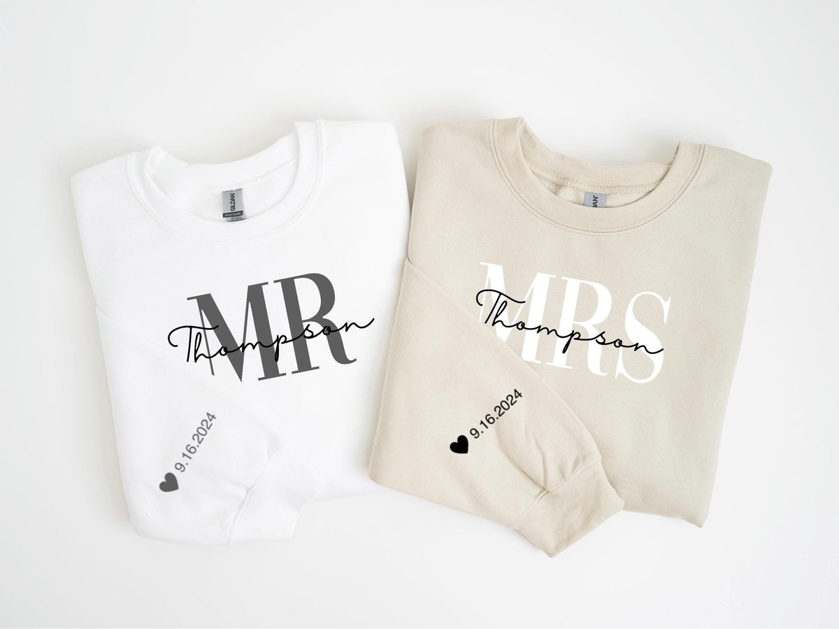 May include: Two matching sweatshirts, one white and one beige, with wedding-themed text. The white sweatshirt says "MR Thompson" in black script and block letters. The beige sweatshirt says "MRS Thompson". Both have the date "9.16.2024" and a heart.