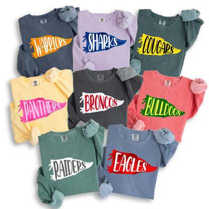 May include: A collection of crewneck sweatshirts in various colors, each featuring a team name in a pennant design. Colors include navy, lavender, yellow, charcoal, coral, green, and blue. The sweatshirts display team names like "Warriors," "Sharks," and "Cougars."