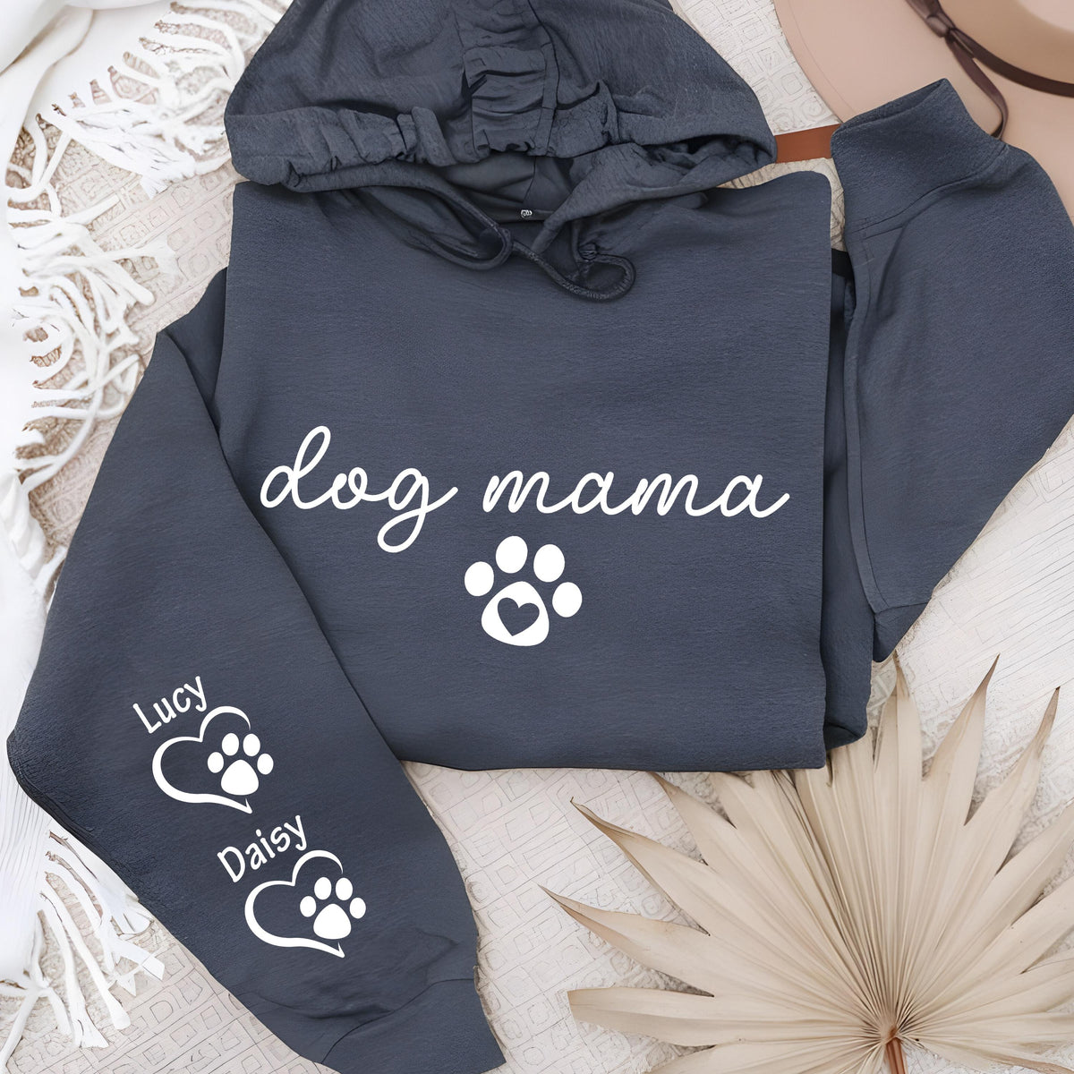 May include: Dark gray hoodie with the text "dog mama" in white script, a white paw print with a heart, and the names "Lucy" and "Daisy" with paw prints inside hearts on the sleeve. The hoodie has a drawstring hood.