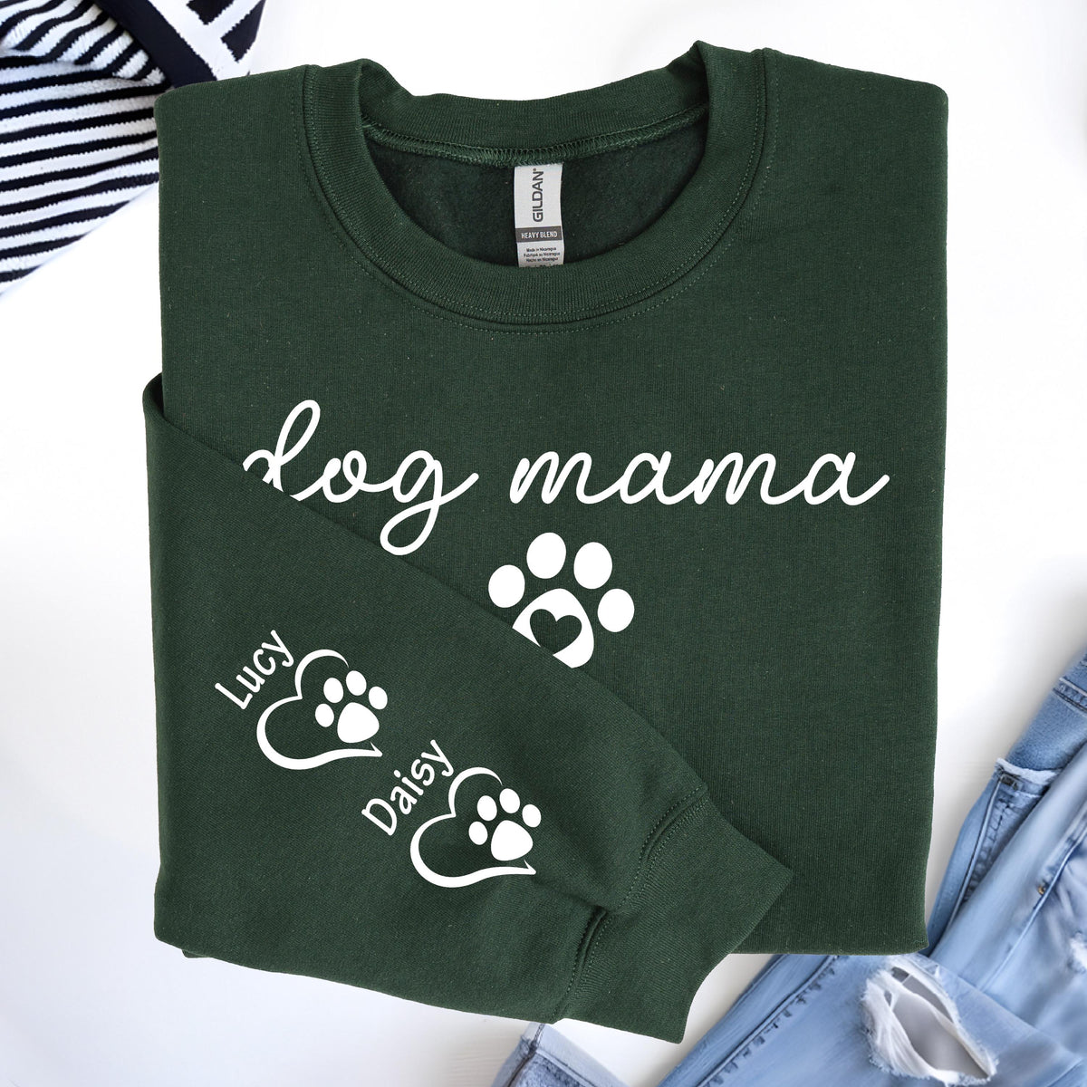 May include: Dark green sweatshirt with the words "dog mama" in white script. A white paw print with a heart is below the text. The sleeve has two paw prints with the names "Lucy" and "Daisy".