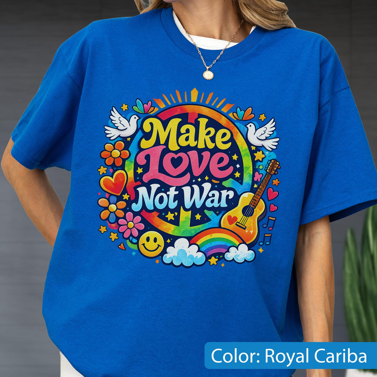 May include: Royal blue t-shirt with a colorful graphic that says "Make Love Not War". The design includes a peace sign, rainbow, guitar, flowers, and doves. The shirt is a crew neck.