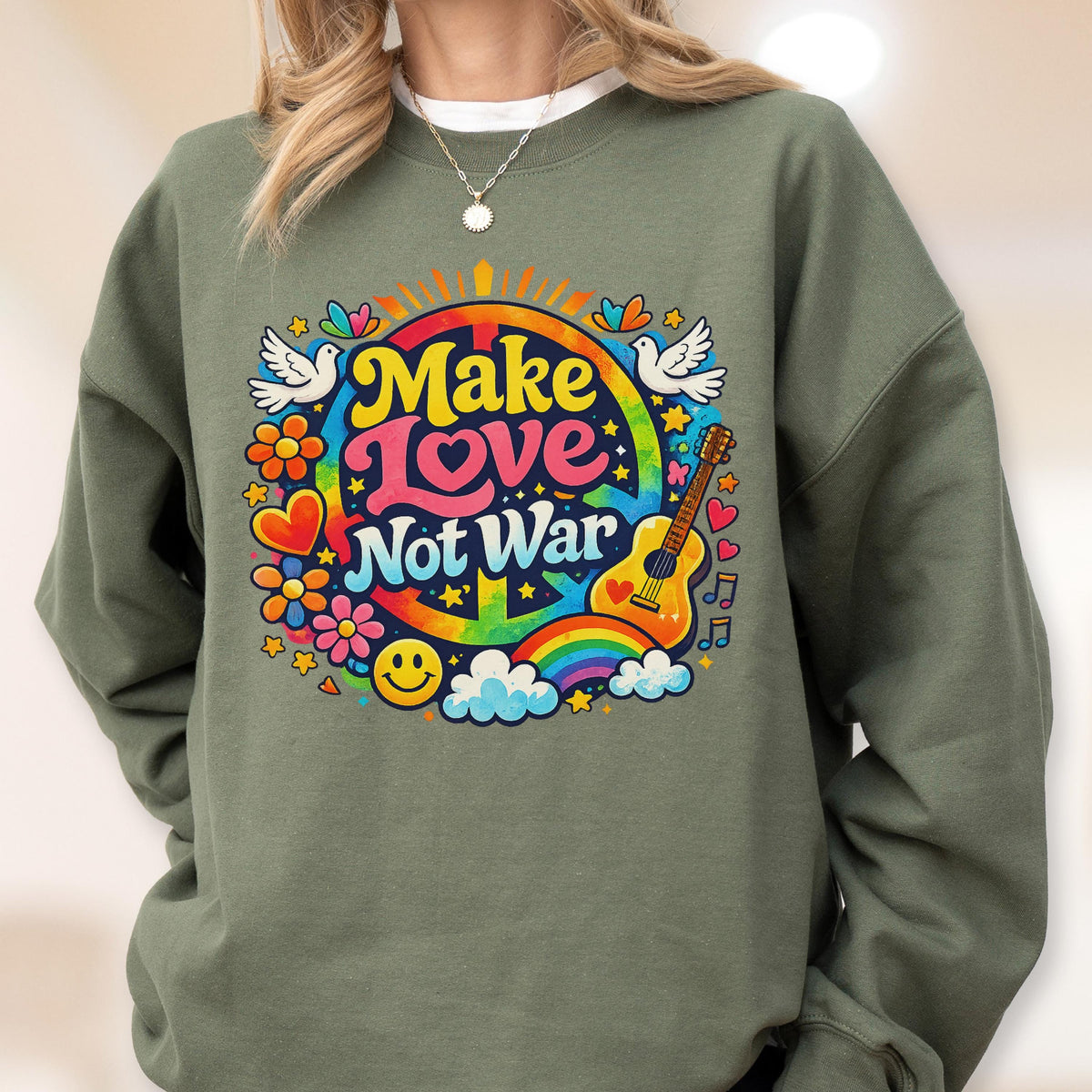 May include: Olive green sweatshirt with a colorful graphic that says "Make Love Not War." The design includes a rainbow, guitar, peace sign, flowers, doves, and a smiley face. The sweatshirt is a casual, comfortable style.