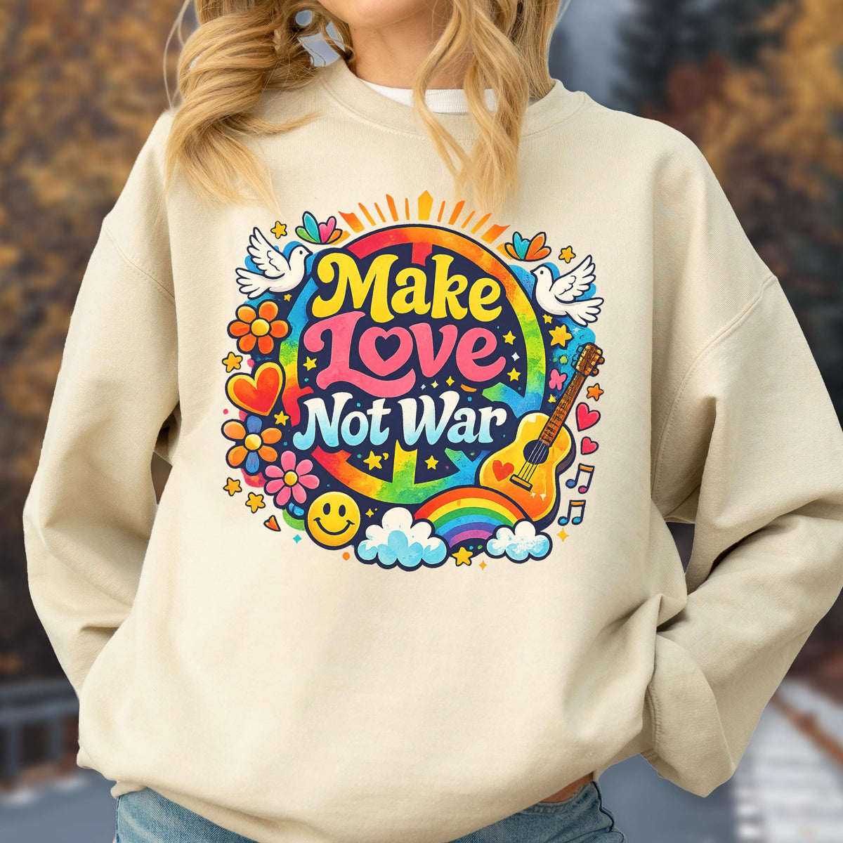 May include: Beige sweatshirt with a colorful graphic that says "Make Love Not War." The design includes a peace sign, rainbow, guitar, flowers, doves, and a smiley face. The sweatshirt is a casual, comfortable style.