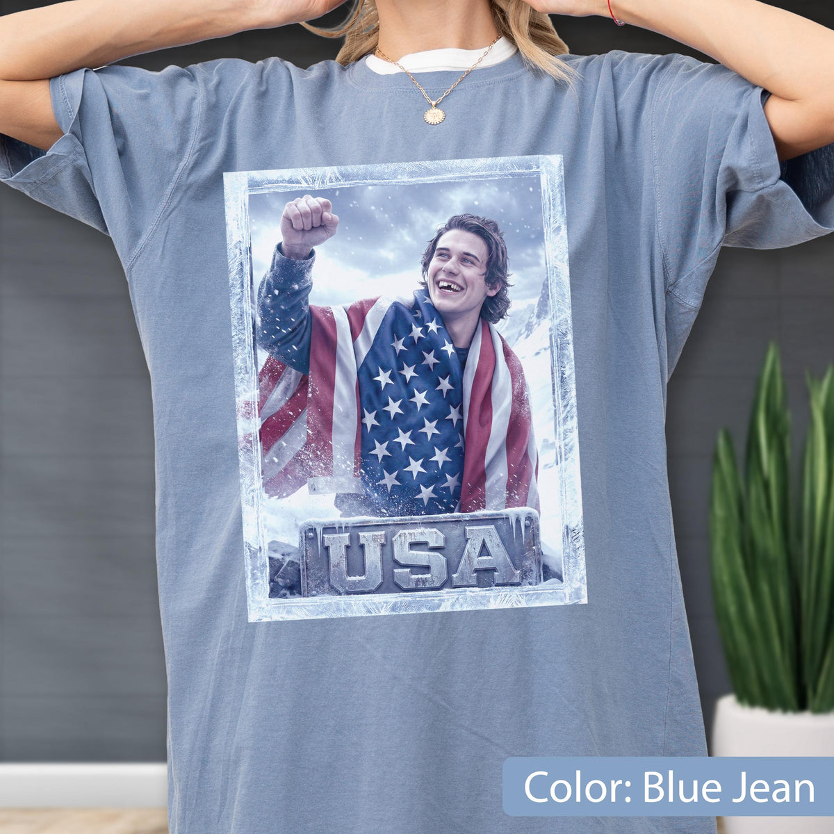 Unisex USA hockey graphic t shirt on Comfort Colors® tee featuring young ice hockey player inspired by Jack Hughes USA gold style, wrapped in American flag with winter frost frame and bold USA lettering design