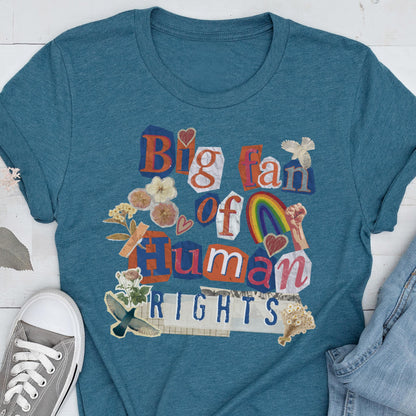 May include: Teal t-shirt with a collage design that reads "Big fan of Human Rights." The design includes a rainbow, hearts, flowers, and a raised fist. The shirt is made of a soft material.
