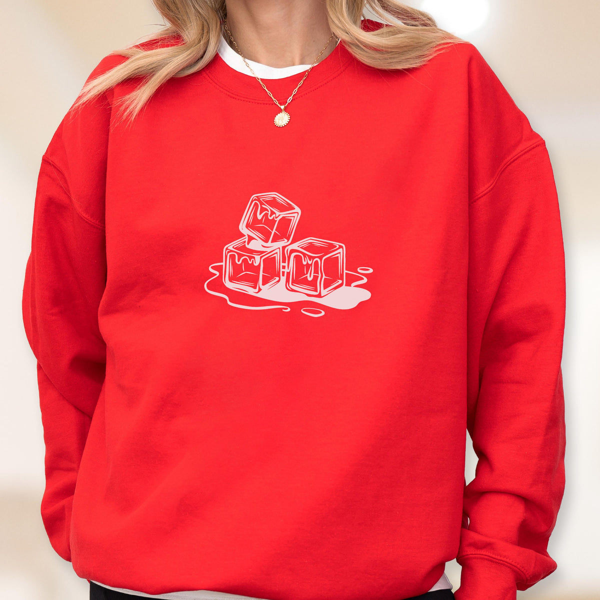 May include: A red sweatshirt featuring a white graphic of three melting ice cubes. The design is centered on the chest. The sweatshirt is a solid red color and has a crew neck.