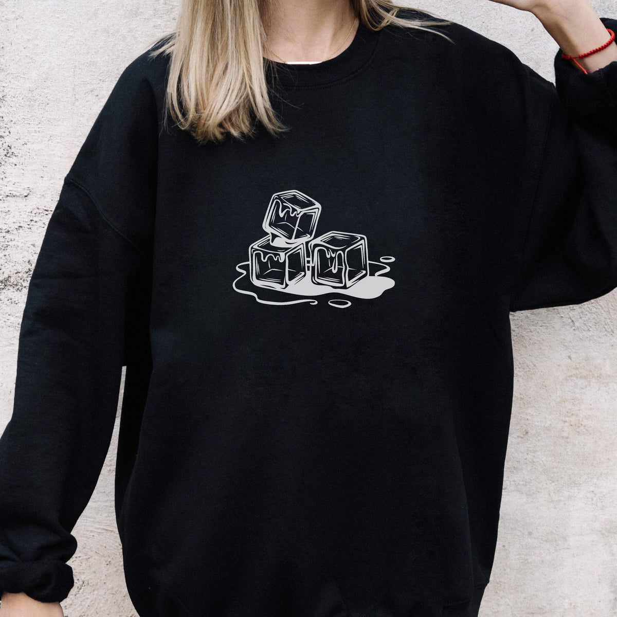 May include: Black sweatshirt featuring a white graphic of three melting ice cubes. The design is a simple line drawing, with the cubes stacked and surrounded by water. The sweatshirt is a casual, unisex style.