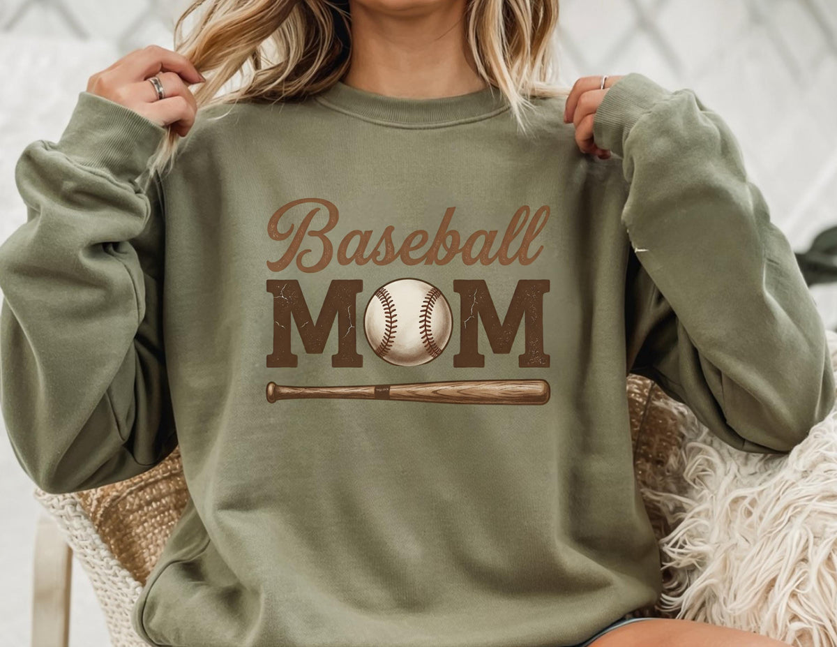 May include: Olive green sweatshirt with the words "Baseball MOM" in brown script and block letters. A baseball and bat graphic are centered below the text. The sweatshirt is a casual style.