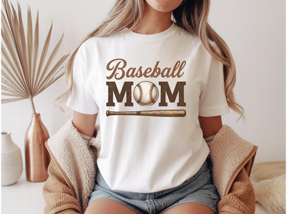 May include: White t-shirt with the words "Baseball MOM" in brown lettering, a baseball graphic, and a baseball bat. The shirt is a casual style, perfect for baseball fans.