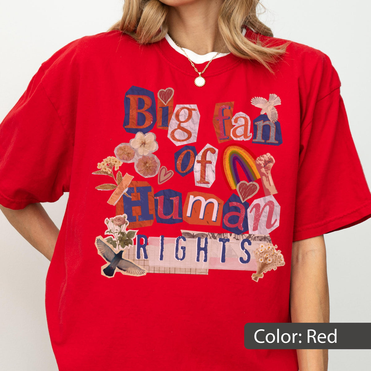 May include: A red t-shirt with the text "Big fan of Human Rights" in a collage style. The design includes a rainbow, flowers, and a raised fist. The shirt is a solid red color.