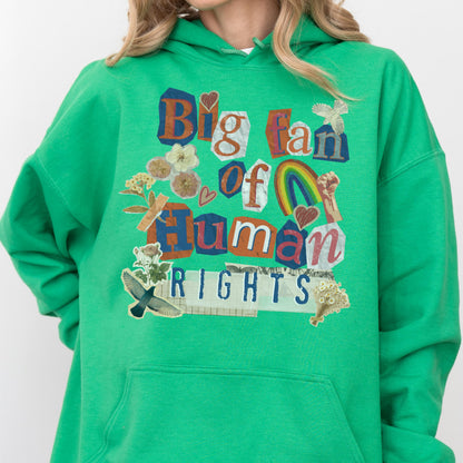 May include: A green hooded sweatshirt with the text "Big fan of Human Rights" in a collage style. The design includes a rainbow, flowers, and a bird. The sweatshirt is a solid green color.