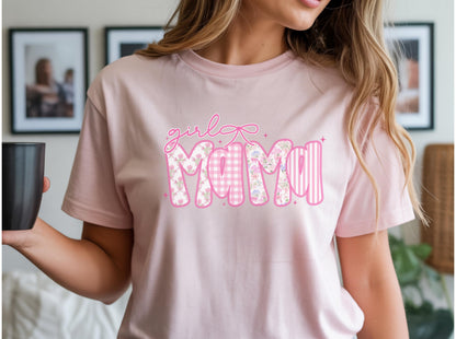 May include: A light pink t-shirt with the words "girl Mama" in a pink script and block letters. The word "Mama" is decorated with floral, gingham, and striped patterns.