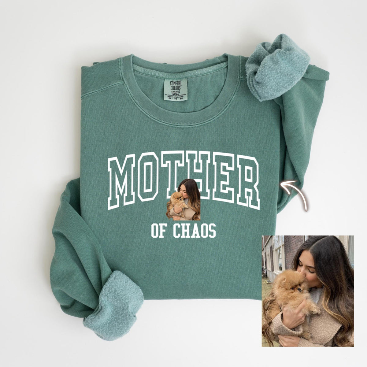 May include: A teal green sweatshirt with the word "MOTHER" in white block letters. Below the word "MOTHER" is a photo of a woman holding a small dog. The words "OF CHAOS" are below the photo.