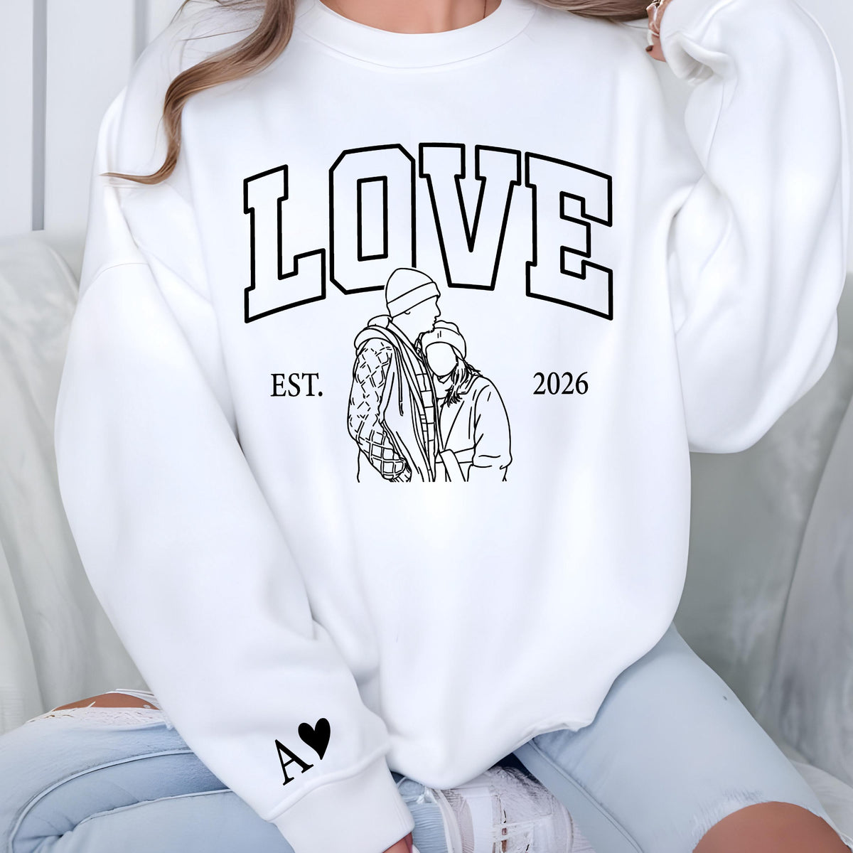 May include: White sweatshirt with the word "LOVE" in large black block letters. Below the word "LOVE" is a black and white line drawing of a couple. The sweatshirt also has the text "EST. 2026" and a black heart with the letter "A".