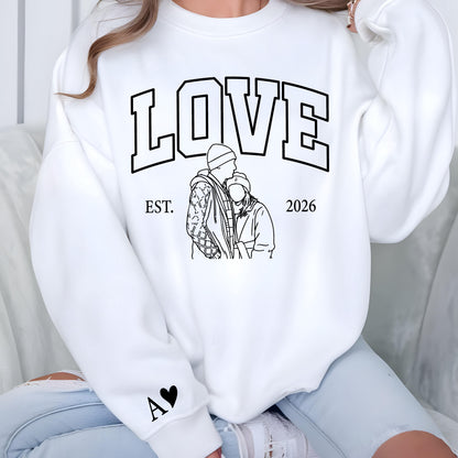 May include: White sweatshirt with the word "LOVE" in large black block letters. Below the word "LOVE" is a black and white line drawing of a couple. The sweatshirt also has the text "EST. 2026" and a black heart with the letter "A".