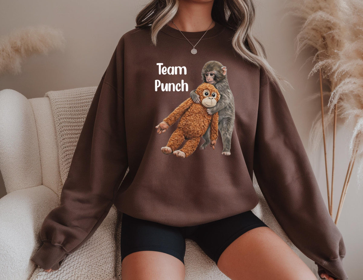 May include: A brown sweatshirt featuring a graphic of two monkeys hugging. The text "Team Punch" is printed above the monkeys in white. The sweatshirt is a solid brown color.