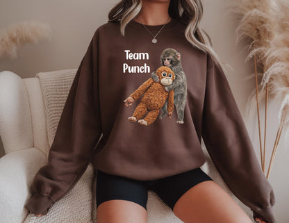 May include: A brown sweatshirt featuring a graphic of two monkeys hugging. The text "Team Punch" is printed above the monkeys in white. The sweatshirt is a solid brown color.