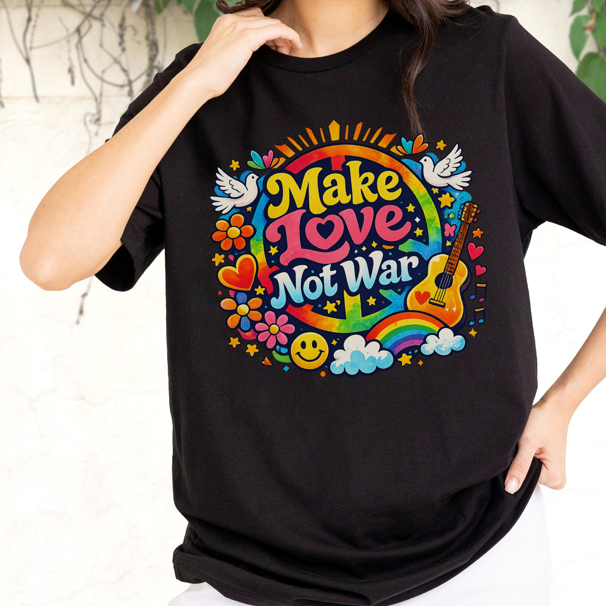 May include: Black t-shirt with a colorful graphic that says "Make Love Not War." The design includes a peace sign, rainbow, guitar, flowers, doves, and a smiley face. The shirt is a classic crew neck.