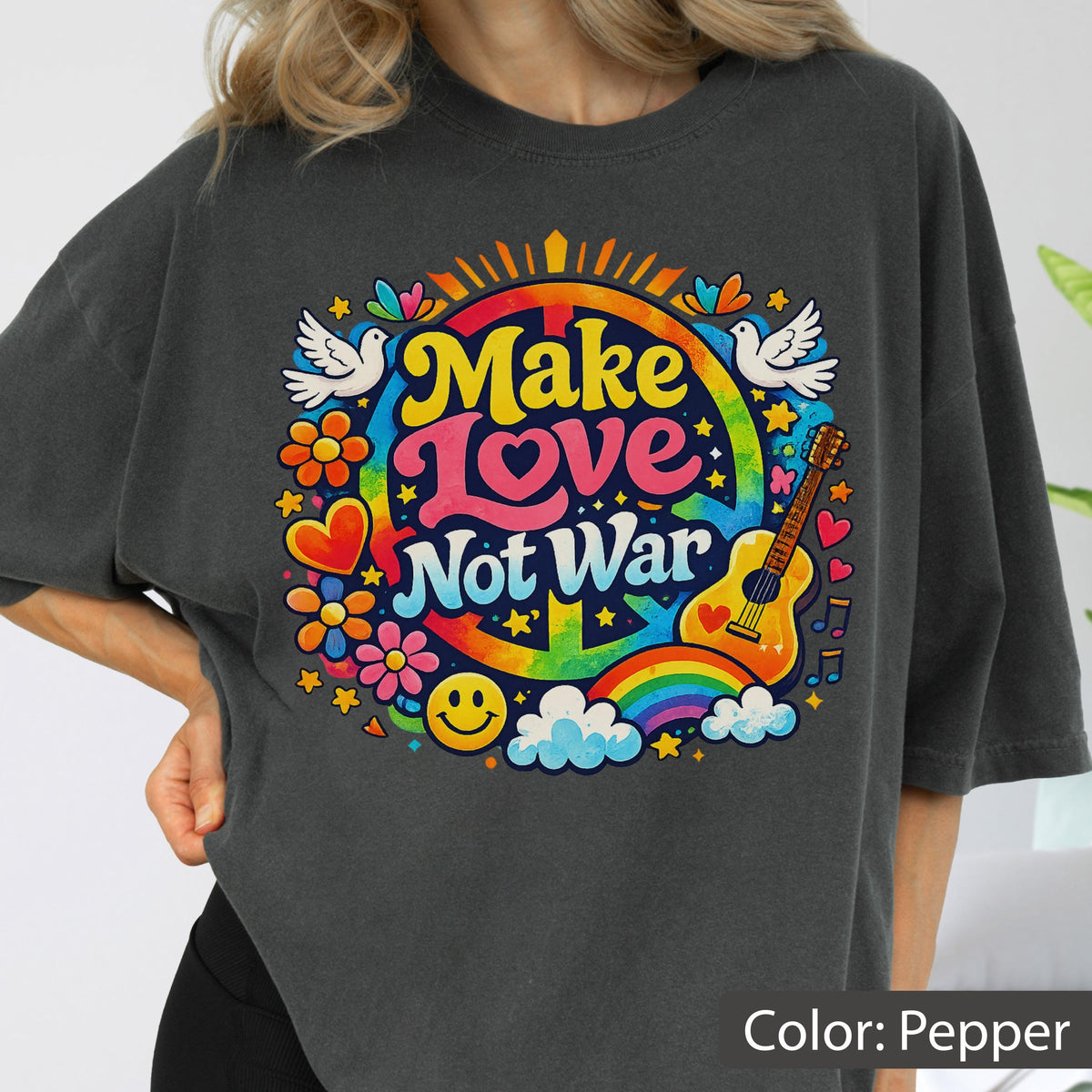 May include: Dark gray t-shirt with a colorful graphic that says "Make Love Not War." The design includes a peace sign, guitar, rainbow, flowers, doves, and a smiley face. The shirt is a relaxed fit.