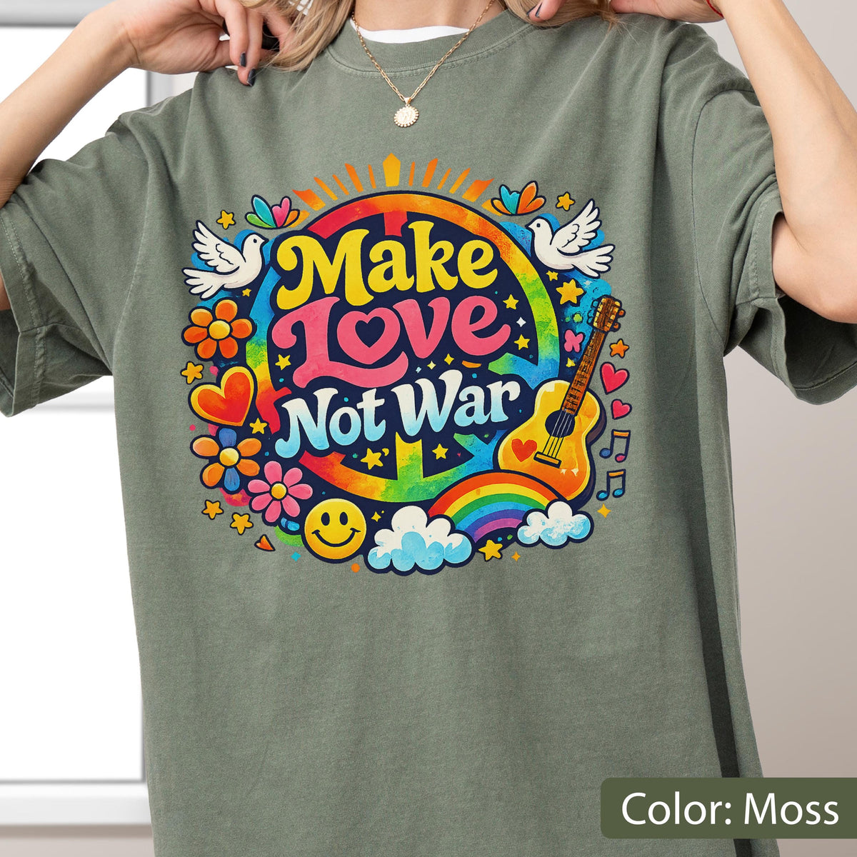 May include: Moss green t-shirt with a colorful "Make Love Not War" graphic. The design includes a peace sign, rainbow, guitar, flowers, doves, and a smiley face. The text is in yellow, pink, and blue.