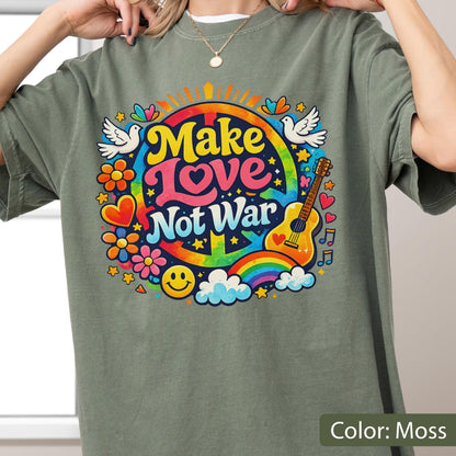 May include: Moss green t-shirt with a colorful "Make Love Not War" graphic. The design includes a peace sign, rainbow, guitar, flowers, doves, and a smiley face. The text is in yellow, pink, and blue.