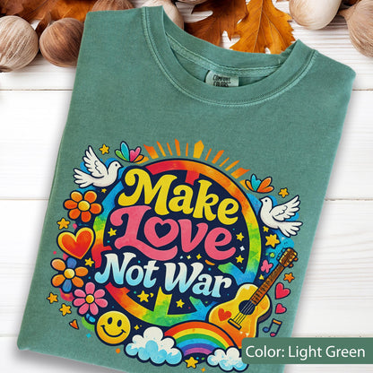 May include: Light green t-shirt with a colorful graphic that says "Make Love Not War". The design includes a peace sign, rainbow, guitar, doves, flowers, and a smiley face. The shirt is a Comfort Colors brand.