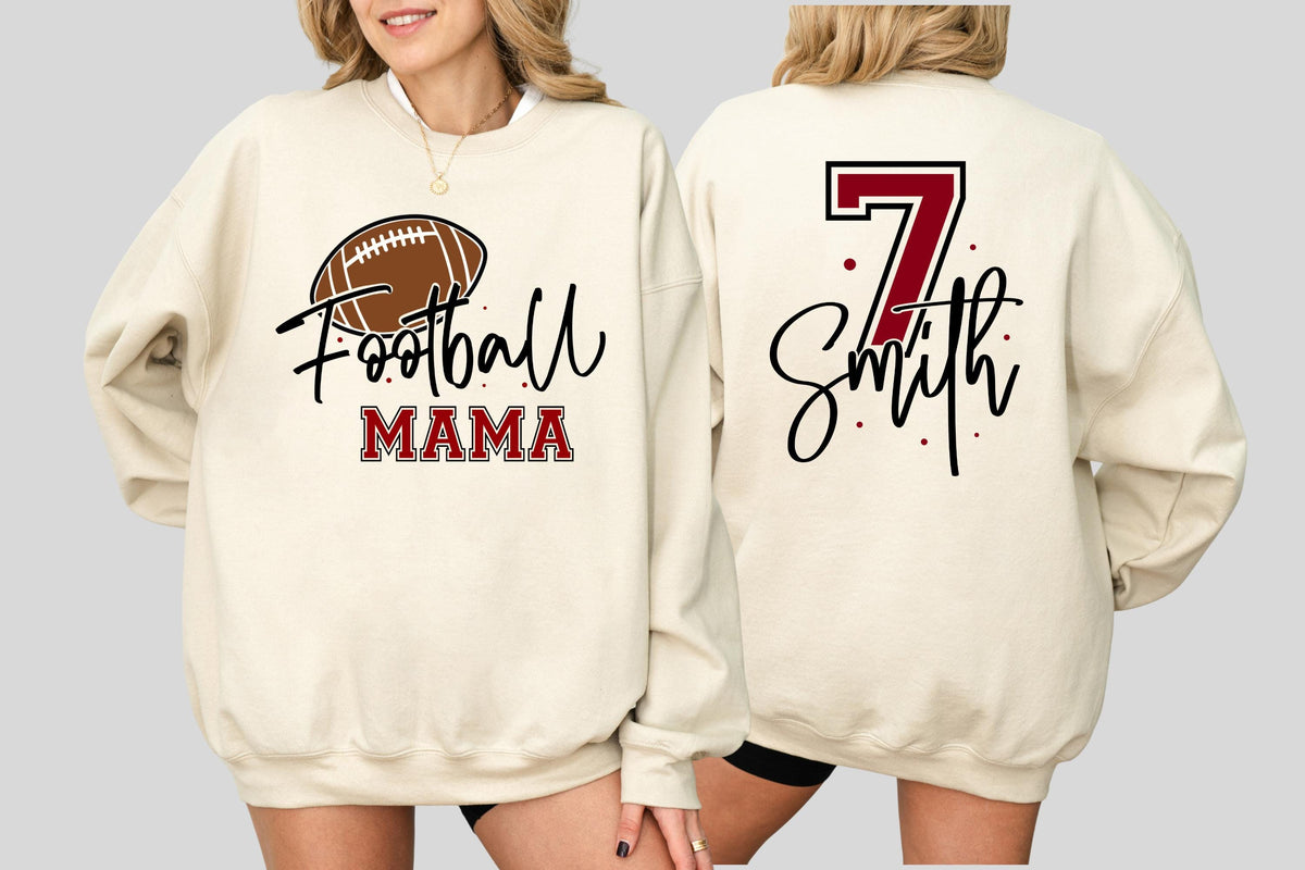 May include: A cream-colored crewneck sweatshirt featuring a graphic on the front with a brown football, the word Football in black script, and the word MAMA in red block letters. The back displays the number 7 in red and the name Smith in black.