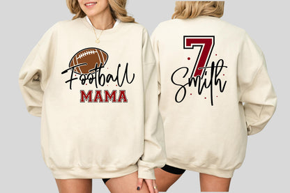 May include: A cream-colored crewneck sweatshirt featuring a graphic on the front with a brown football, the word Football in black script, and the word MAMA in red block letters. The back displays the number 7 in red and the name Smith in black.